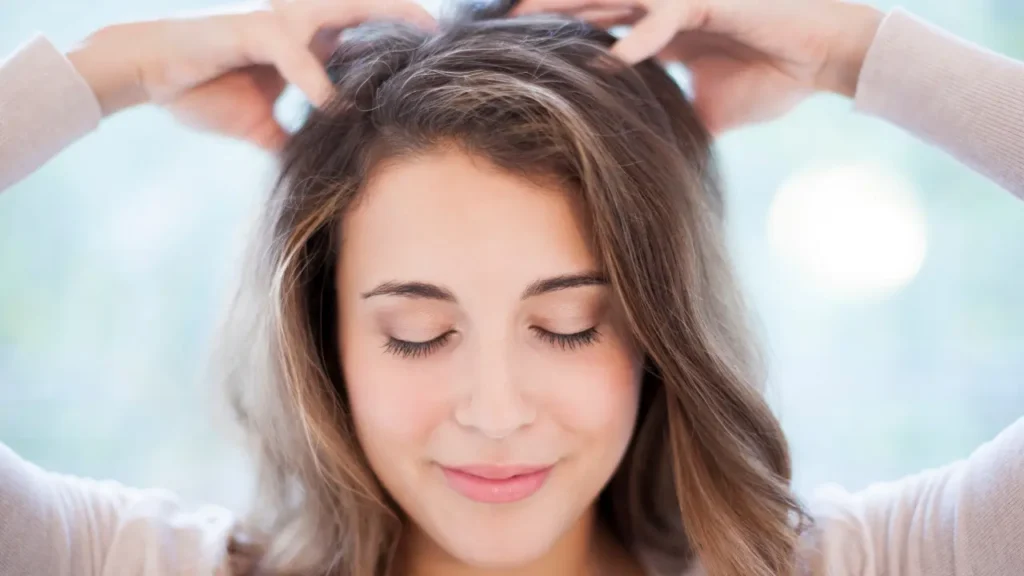 A woman in a white bathrobe looks into a circular mirror with a shocked expression while holding a hairbrush; text overlay reads "Best Winter Hair Care Tips to Prevent Hair Fall and Dryness."