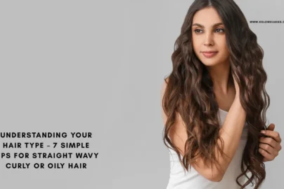 A woman with long, voluminous wavy brown hair looking to the side against a grey background, illustrating the "wavy" hair type category.