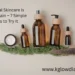 A collection of natural skincare products in amber glass bottles with wooden caps, including a pump bottle, a spray bottle, and two dropper bottles, arranged alongside a jar of white cream and green moss on a neutral background.